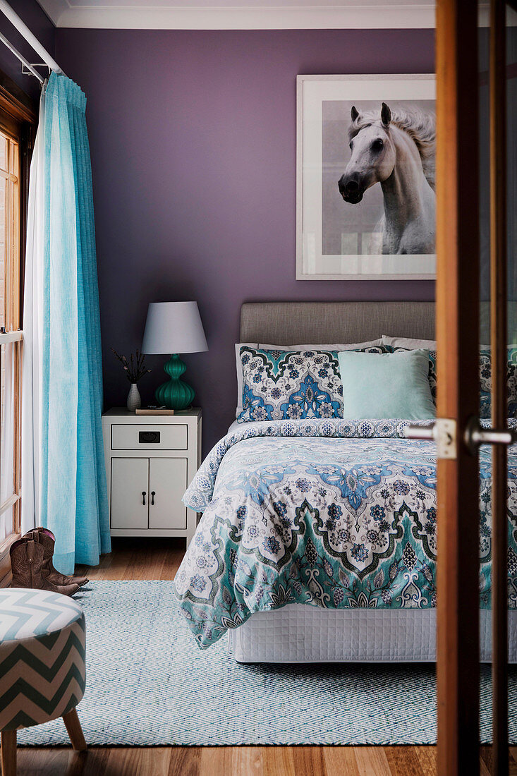 Horse picture on purple wall above bed in bedroom