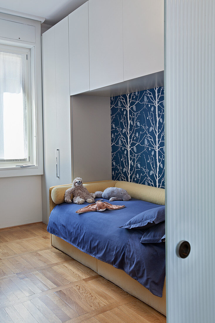 Fitted cupboards above and surrounding bed in child's bedroom