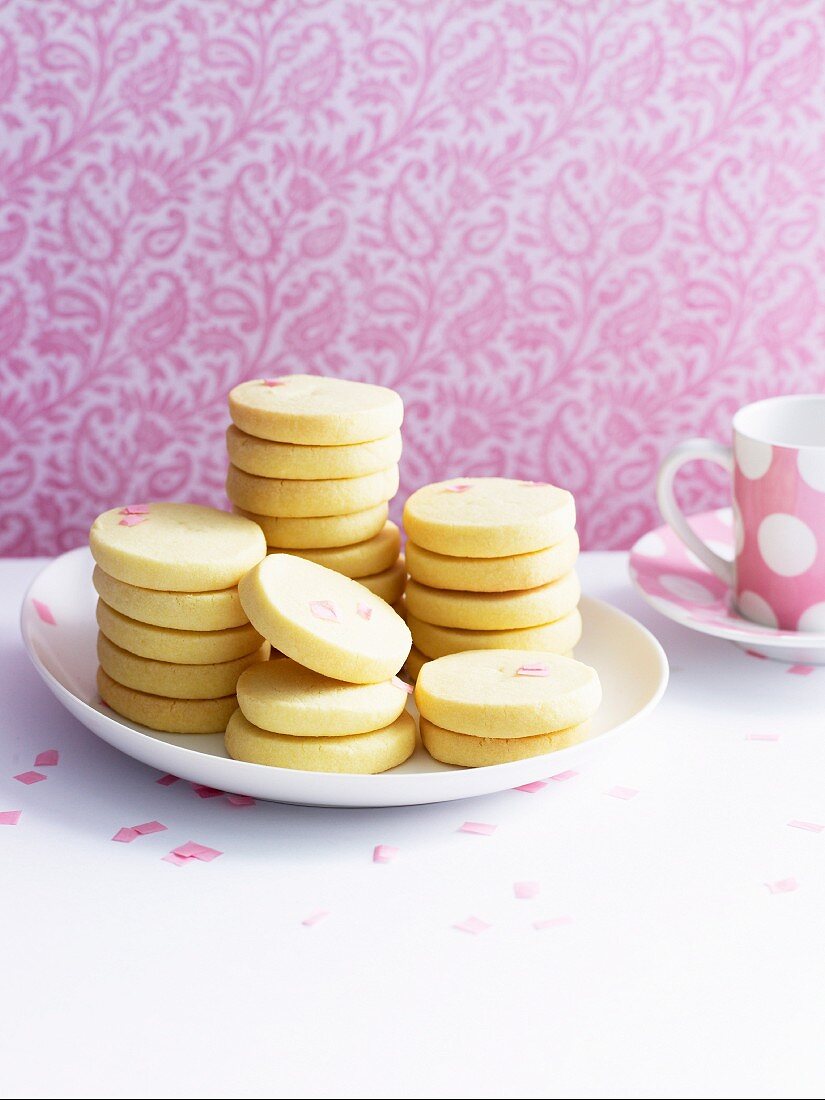 Butter biscuits on plate in front of pink wallpaper