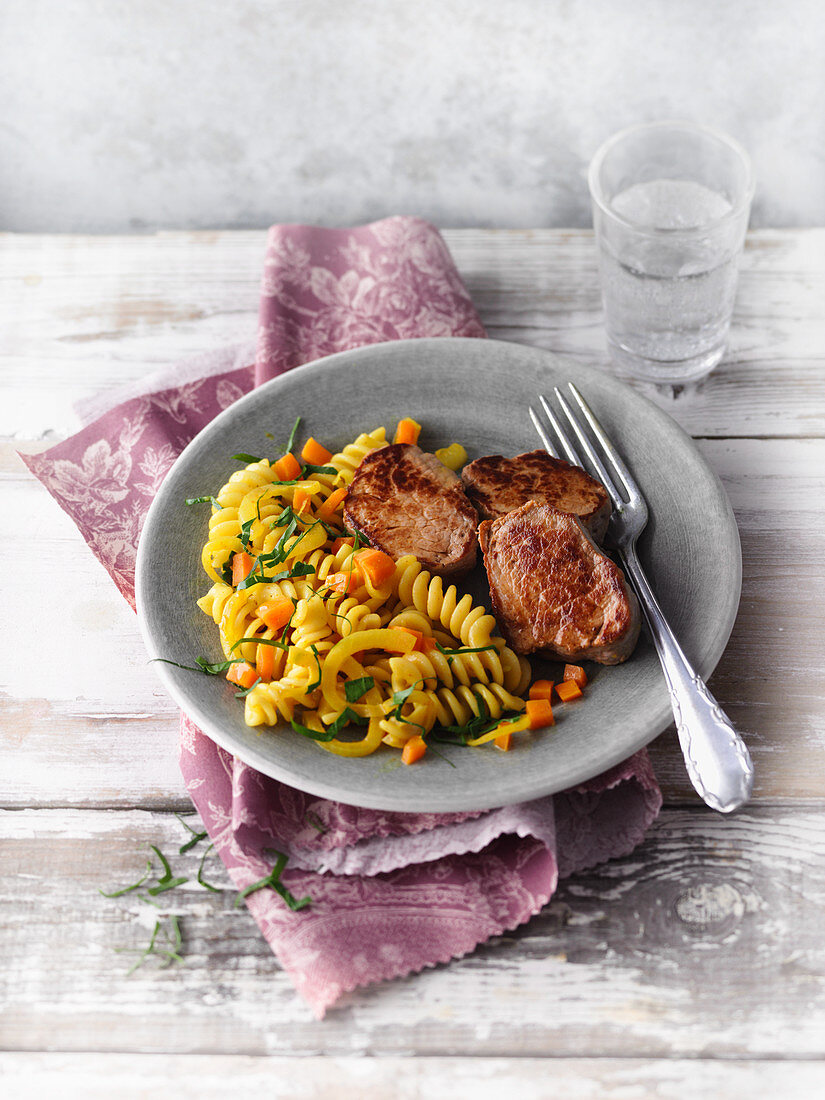 Fried pork medallions with coconut and carrot pasta