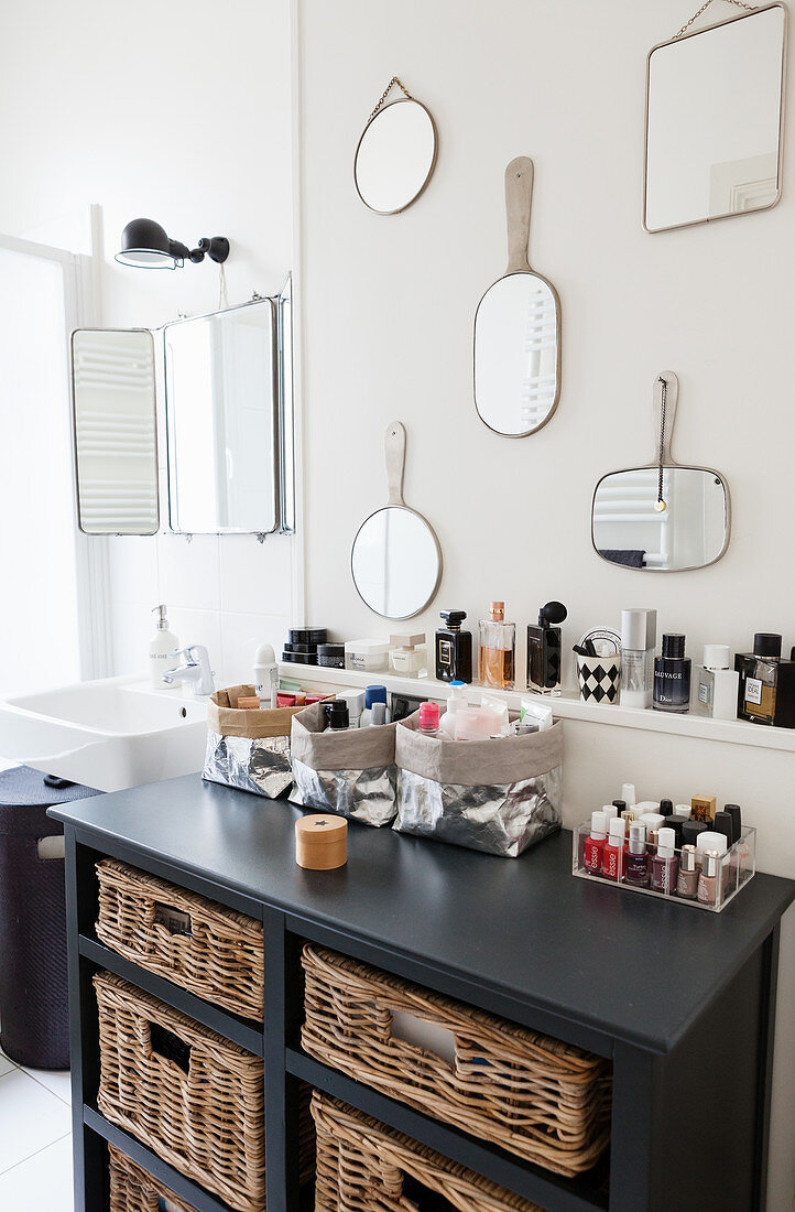 Various mirrors on wall above chest of drawers in bathroom