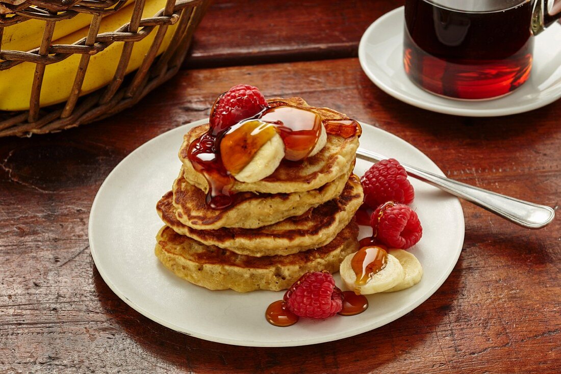 Banana oat pancakes with banana, raspberries and maple syrup (USA)