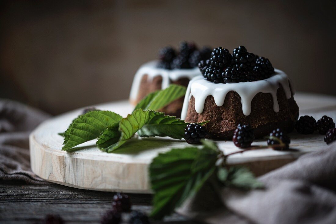 Small vegan ring cakes with icing and fresh blackberries