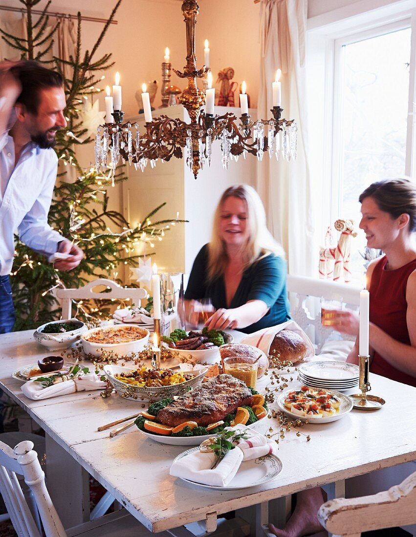 A family sitting around a table set for Christmas dinner