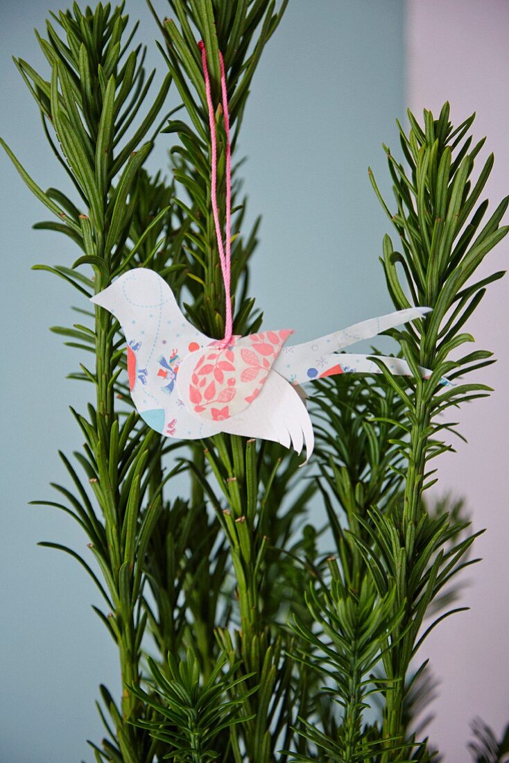 Paper bird hung on yew branch