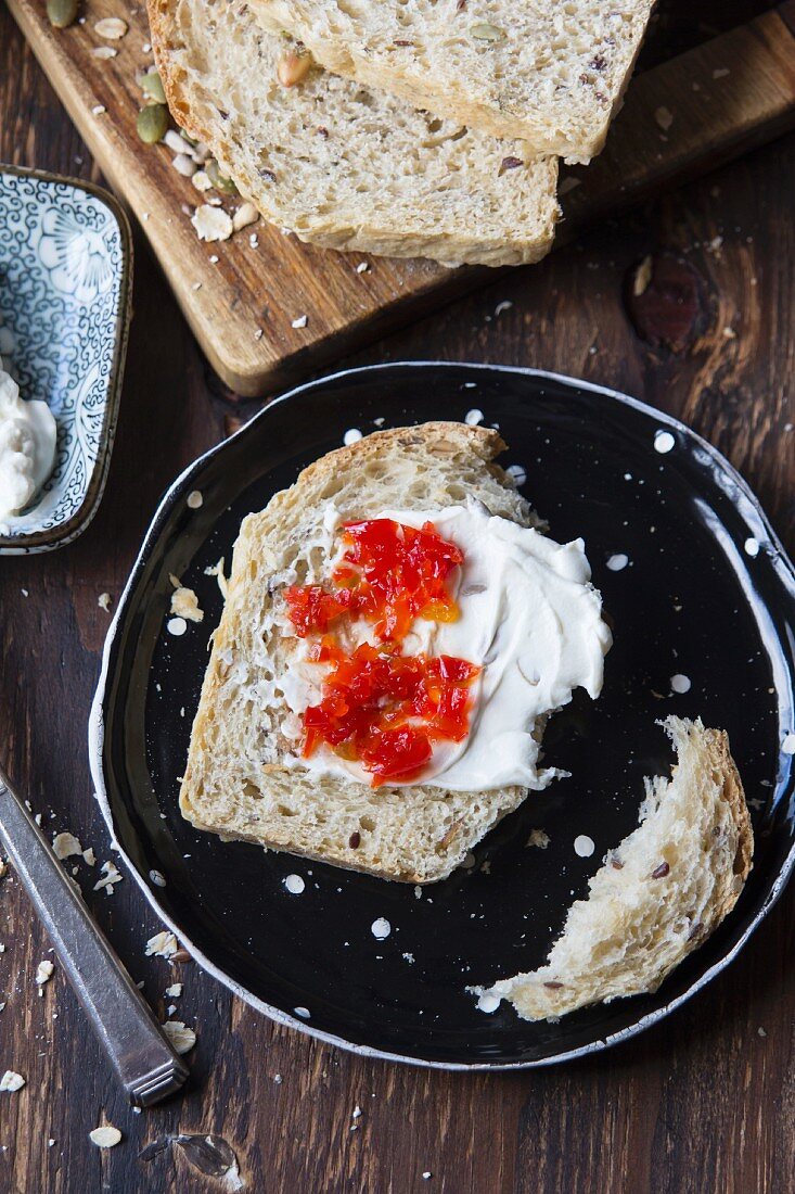 A slice of wholegrain bread with cream cheese and chilli jam