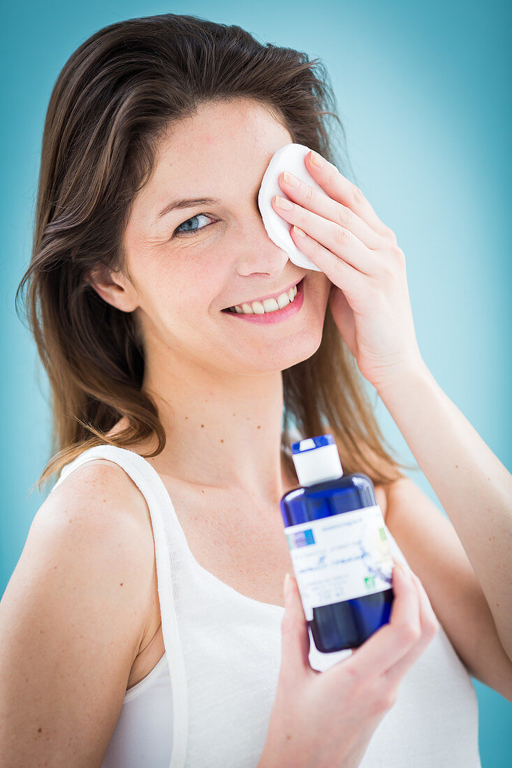 Woman applying a compress on the eyes