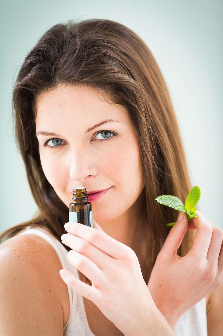 Woman smelling a bottle of essential oil