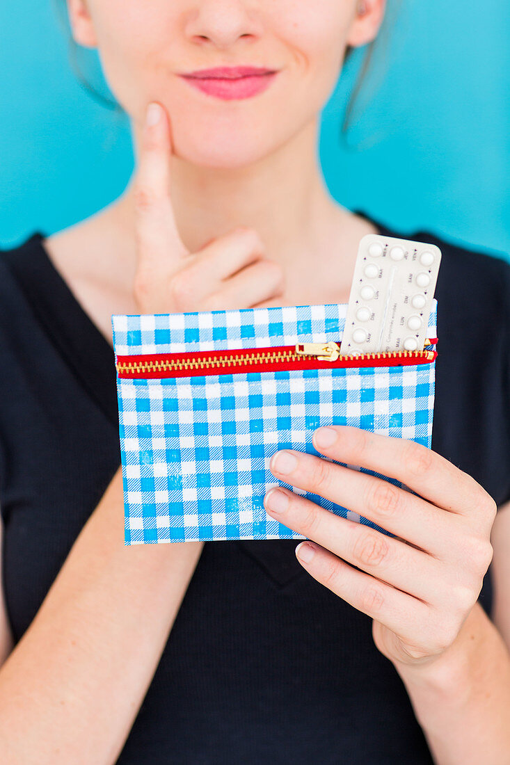 Woman holding contraceptive pills