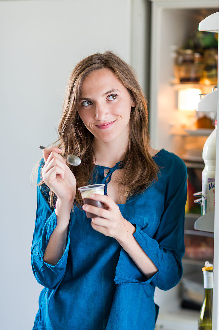 Woman eating yoghurt with chocolate