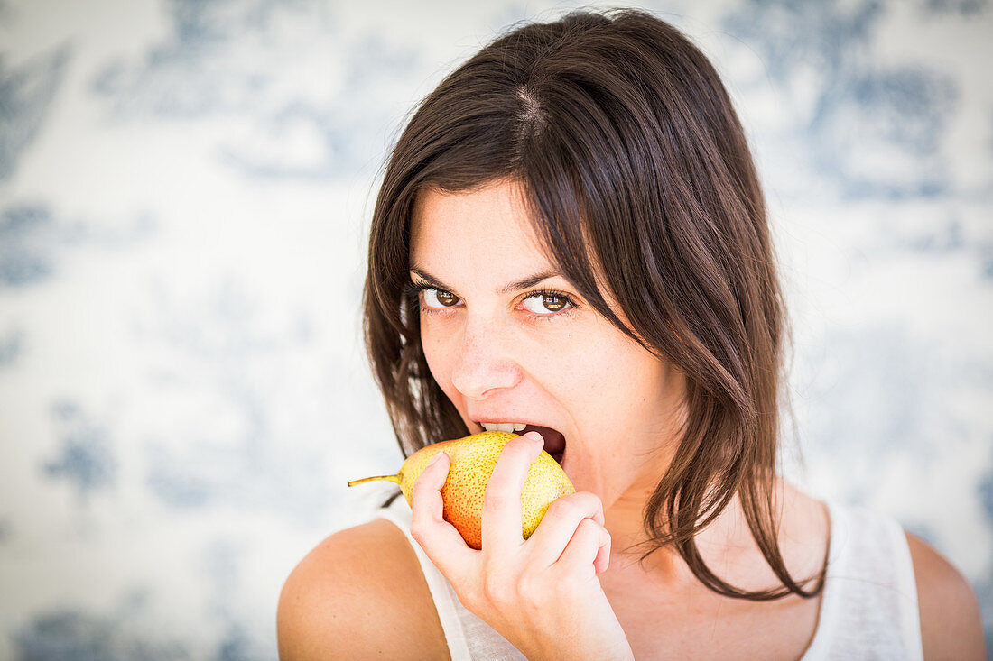 Woman eating a pear