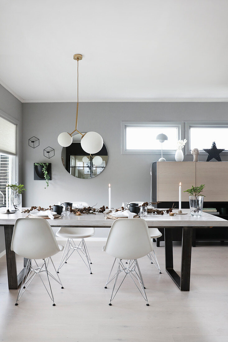 Festively decorated dining table and classic chairs in bright, open-plan interior
