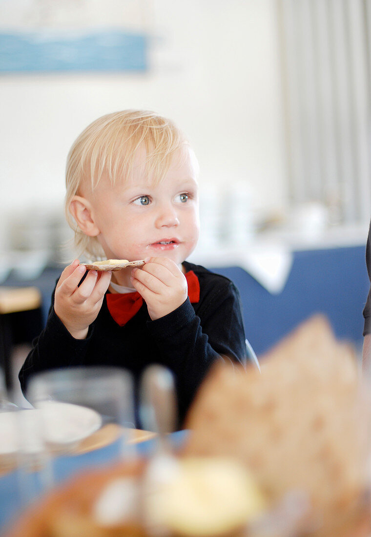 Kind isst Knäckebrot mit Butter