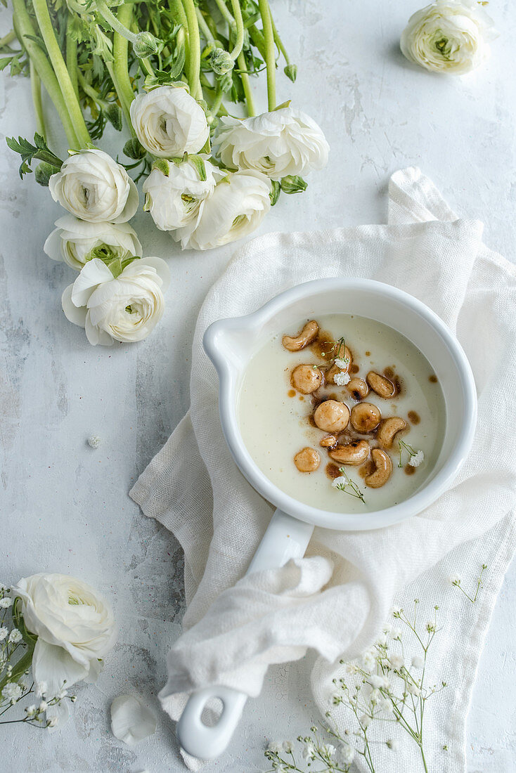 Pudding with macadamia nuts and cashews served in a white pot