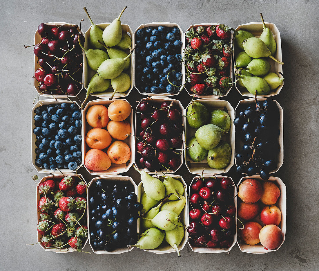 Verschiedene frische Früchte in Pappschalen (Aufsicht)