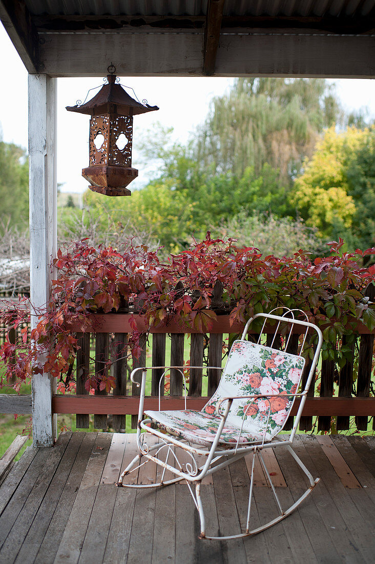 Vintage rocking chair with seat cushion on wooden veranda