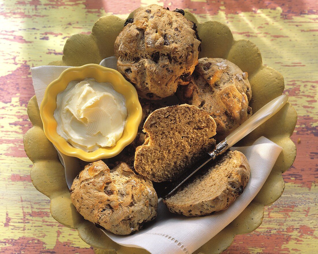 Rosinen-Nuss-Brötchen mit Dinkel in Brotschale mit Butter