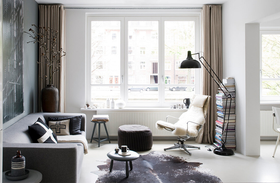 Masculine living room in shades of grey with large windows