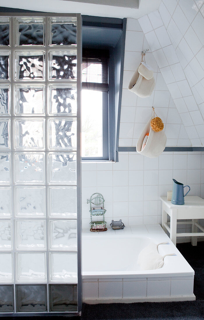 Glass-brick partition screening sunken bathtub