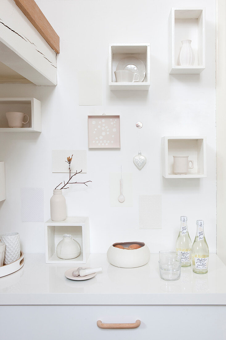 Ornaments in small white shelving modules on wall