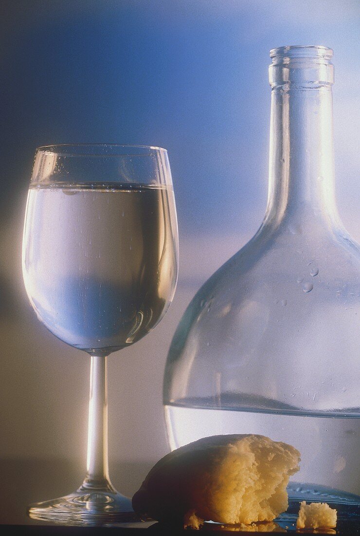 Glas Mineralwasser, Stück Brot & Wasserflasche