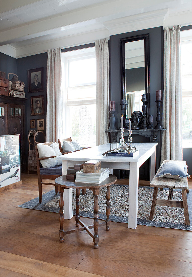 White dining table, wooden bench and chairs in room with grey walls