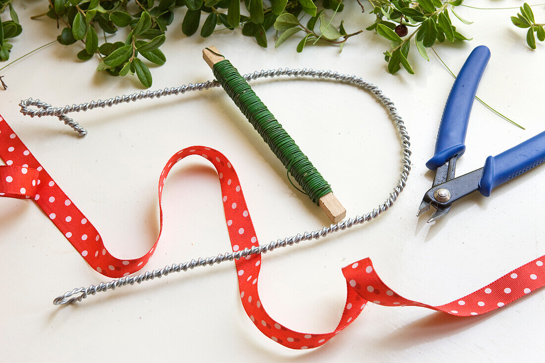 Wire wrapped letter U with red decorative ribbon