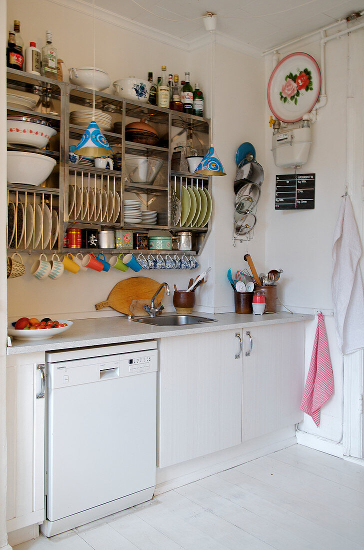 Regal mit Geschirr in schlichter Küche mit weißem Boden