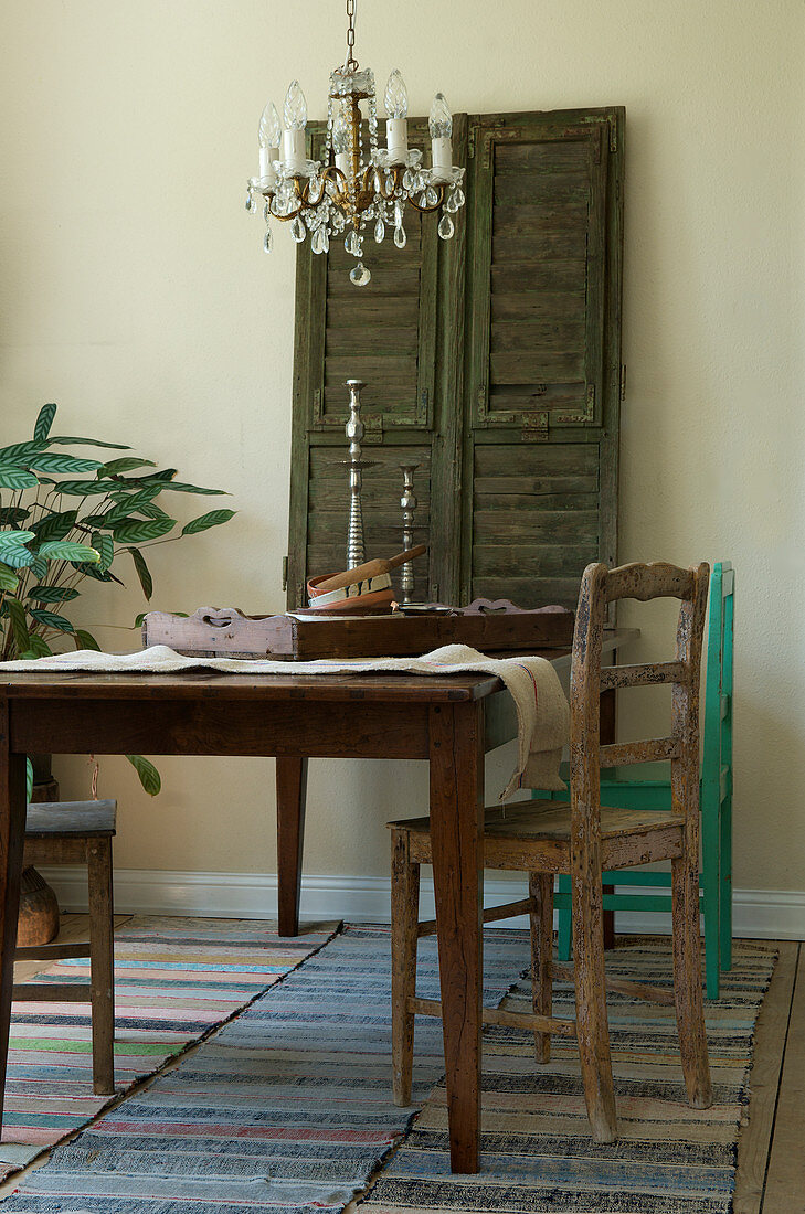 Holztisch und alte Stühle im rustikalen Esszimmer in Naturtönen