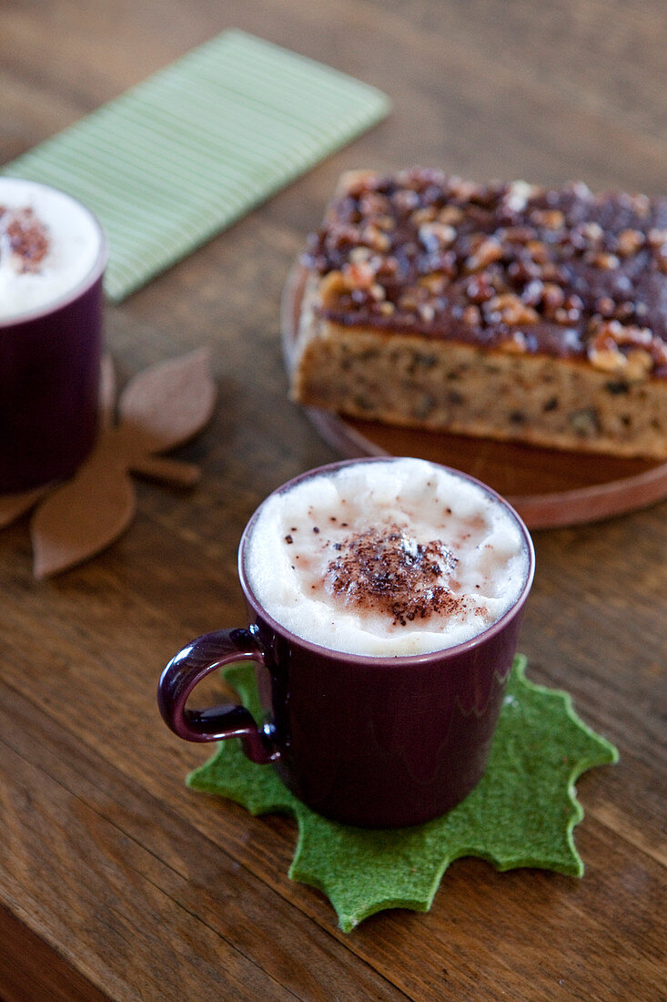 Cocoa with cream in brown cups on autumn felt coasters