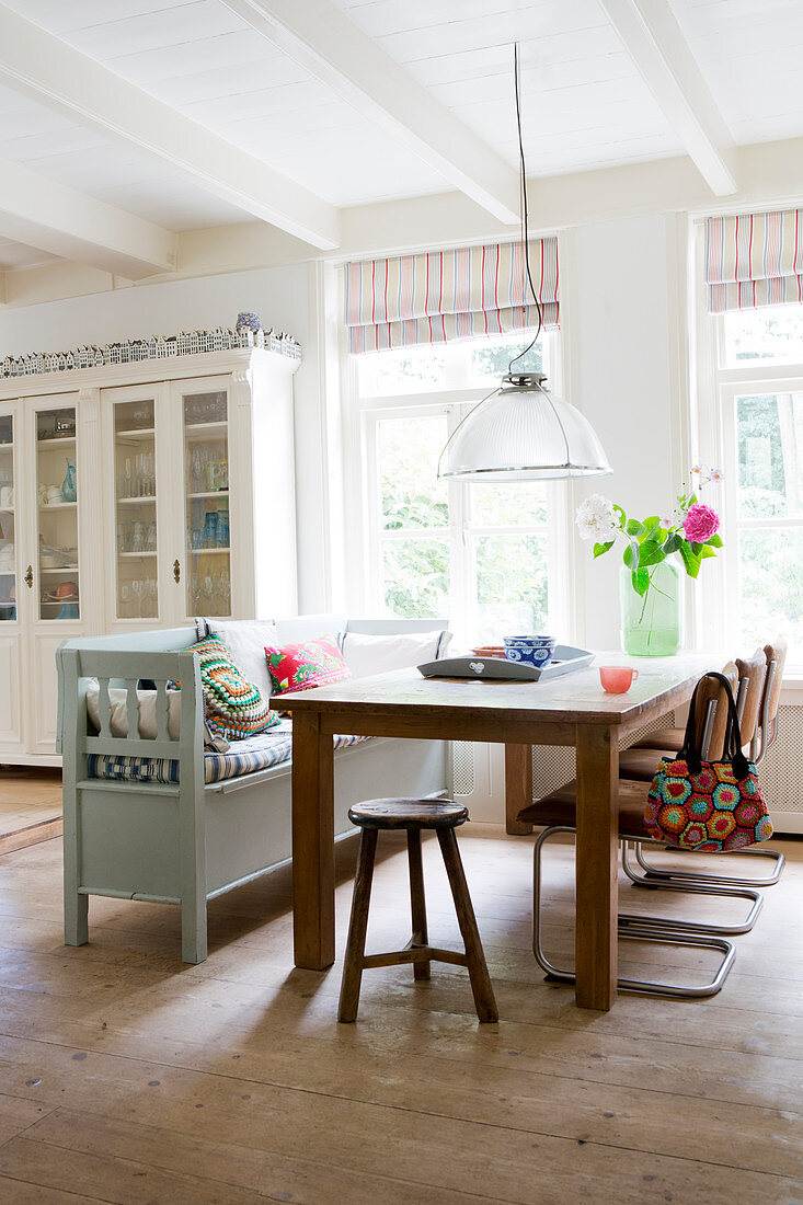 Table with stool, cantilever chair, and bench in the open dining area