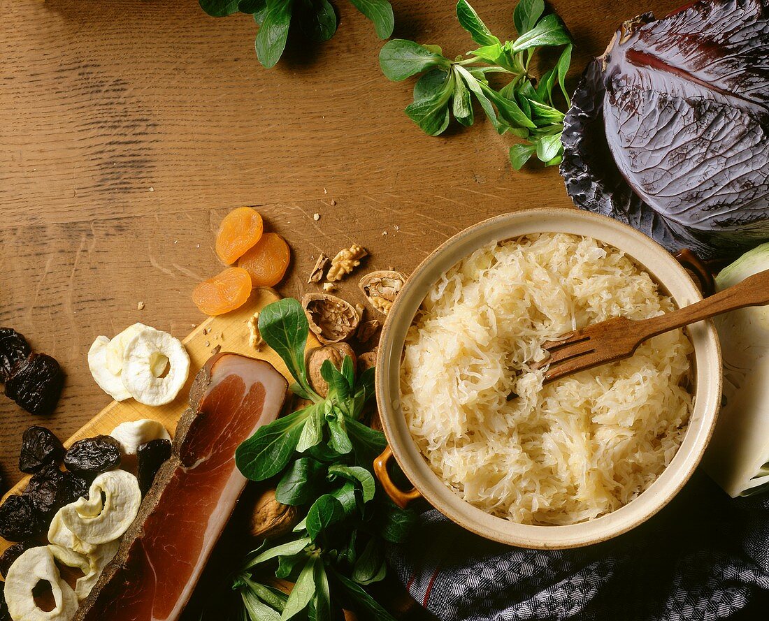 Sauerkraut in pot from above, décor: dried fruit, ham