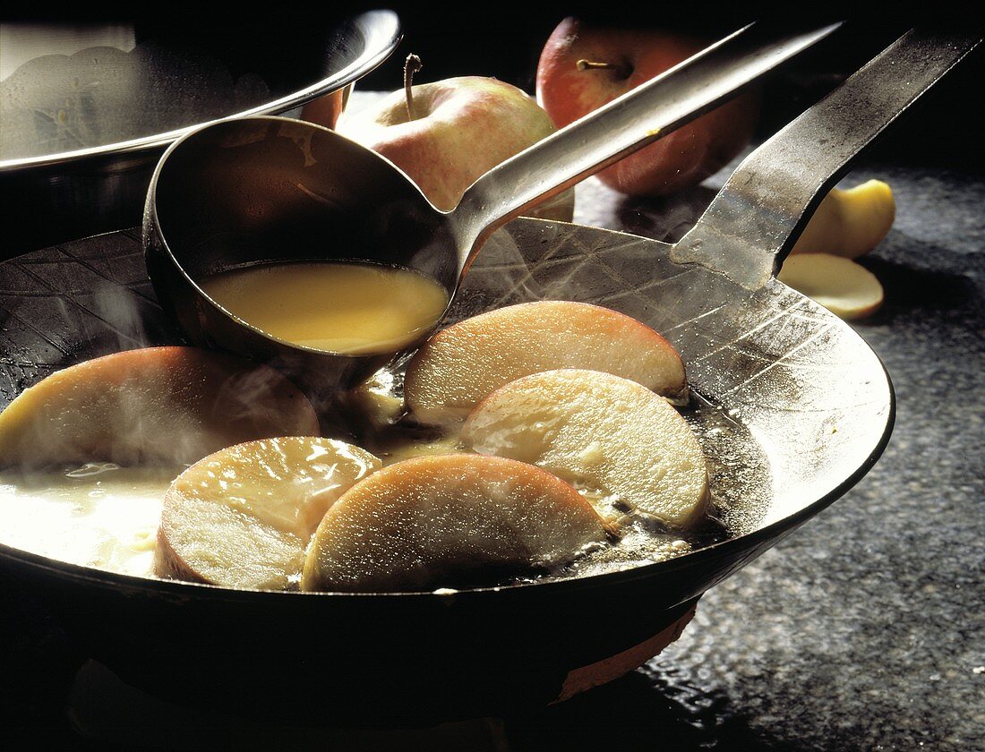 Making Apple Pancakes; Pouring Batter over Apples in a Pan