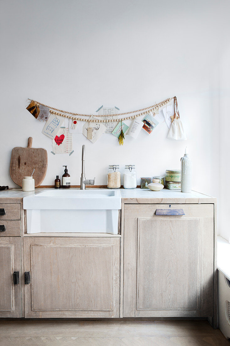 Wooden pearl necklace and greeting cards above the kitchen unit with sink