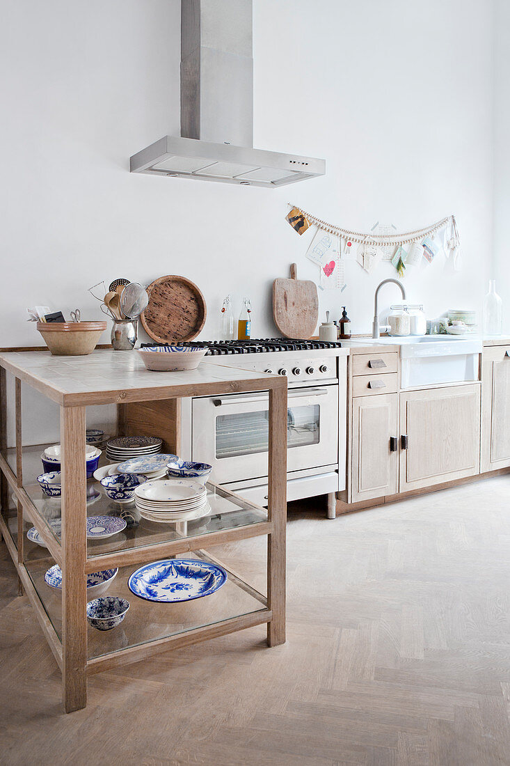 Counter shelf with blue and white dishes in a bright kitchen