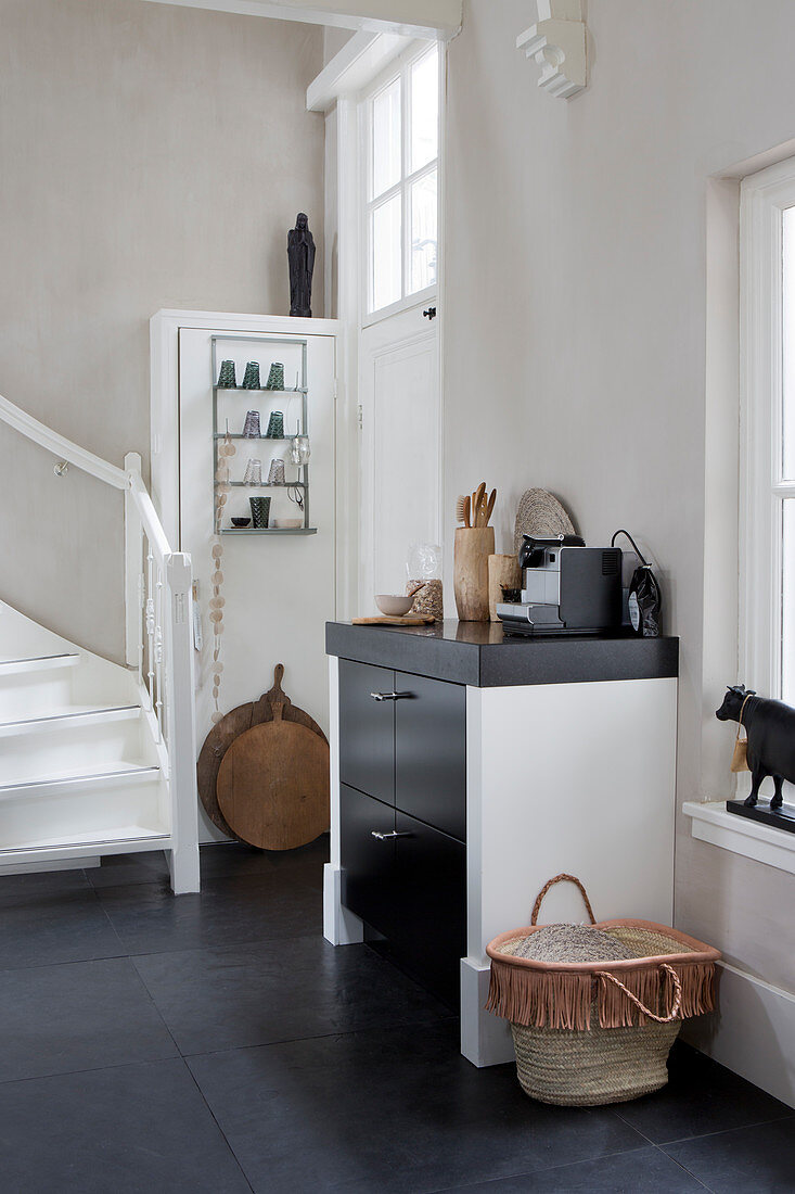 Kitchen counter with ethnic accessories next to foot of staircase in open-plan interior