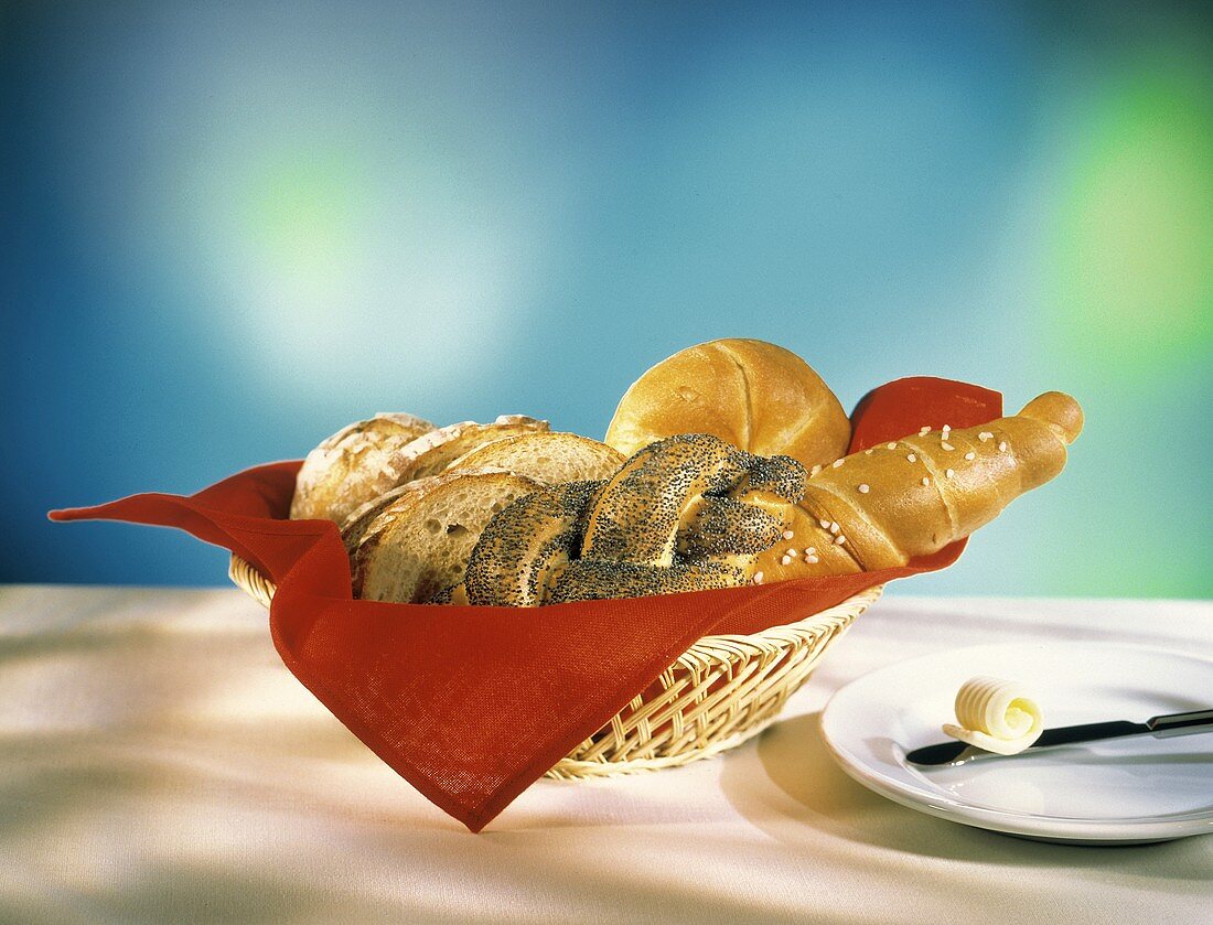 Salzstange,Mohnzopf,Semmel,Brot im Brotkorb & Butterröllchen