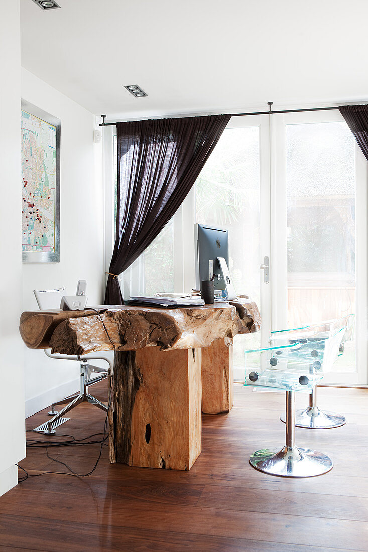 Transparent shell chairs at rustic desk made from live-edge wood
