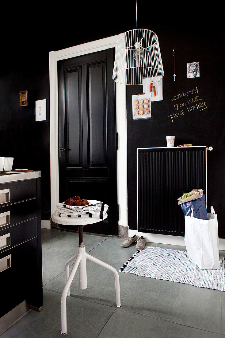 White swivel stool in front of the counter in a black kitchen