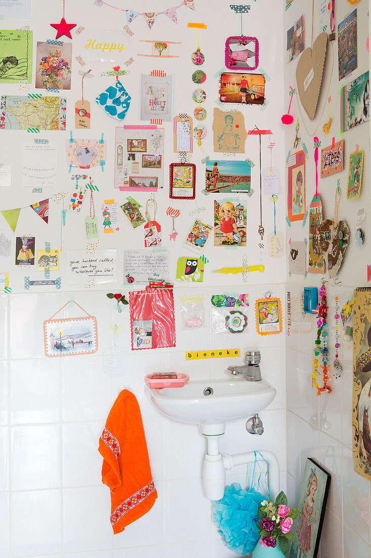 Colourful gallery of items stuck on wall with washi tape above sink