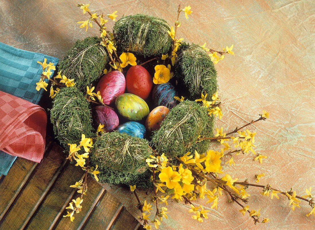 Coloured Easter eggs in Easter wreath of moss & twigs