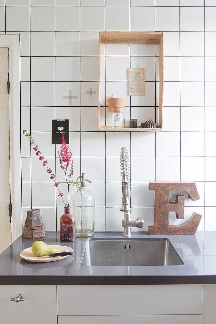 Wooden box as a wall shelf on the tiled wall above the sink