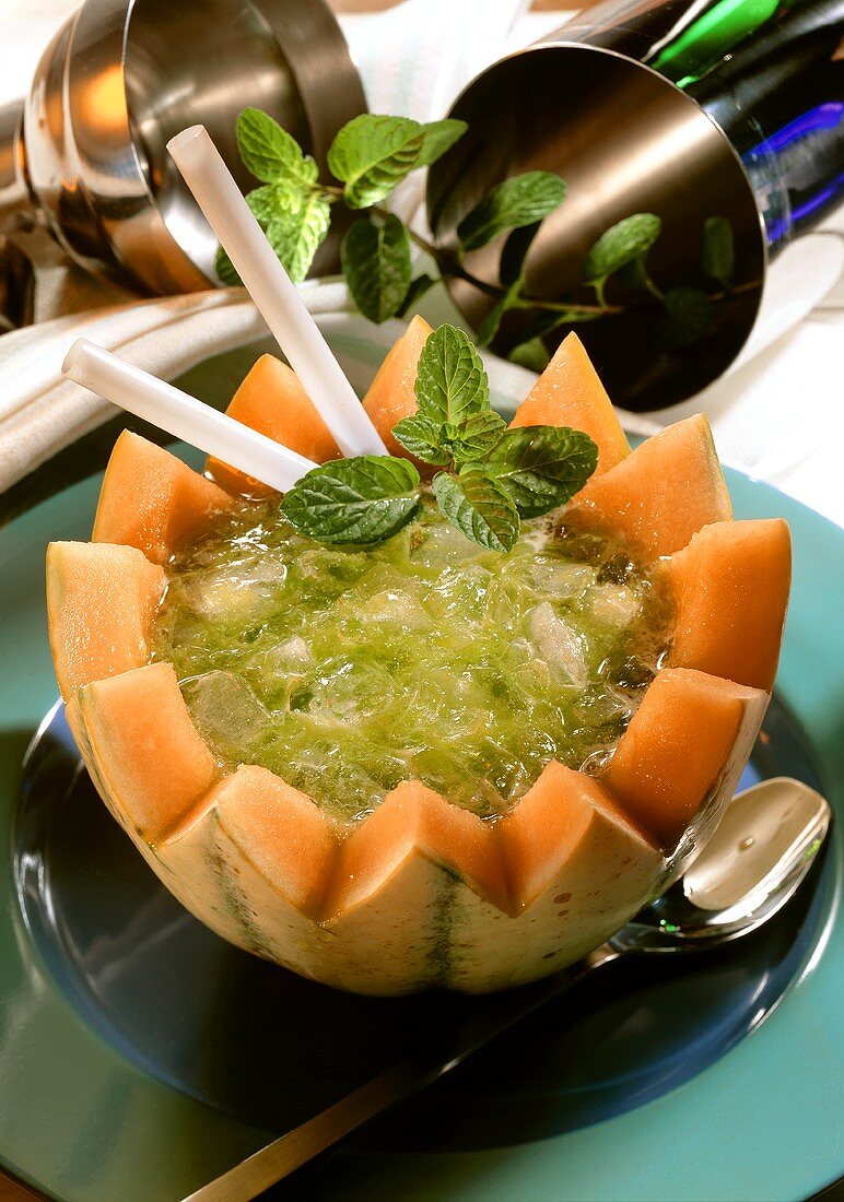 Melon drink with mint and ice in half a honeydew melon