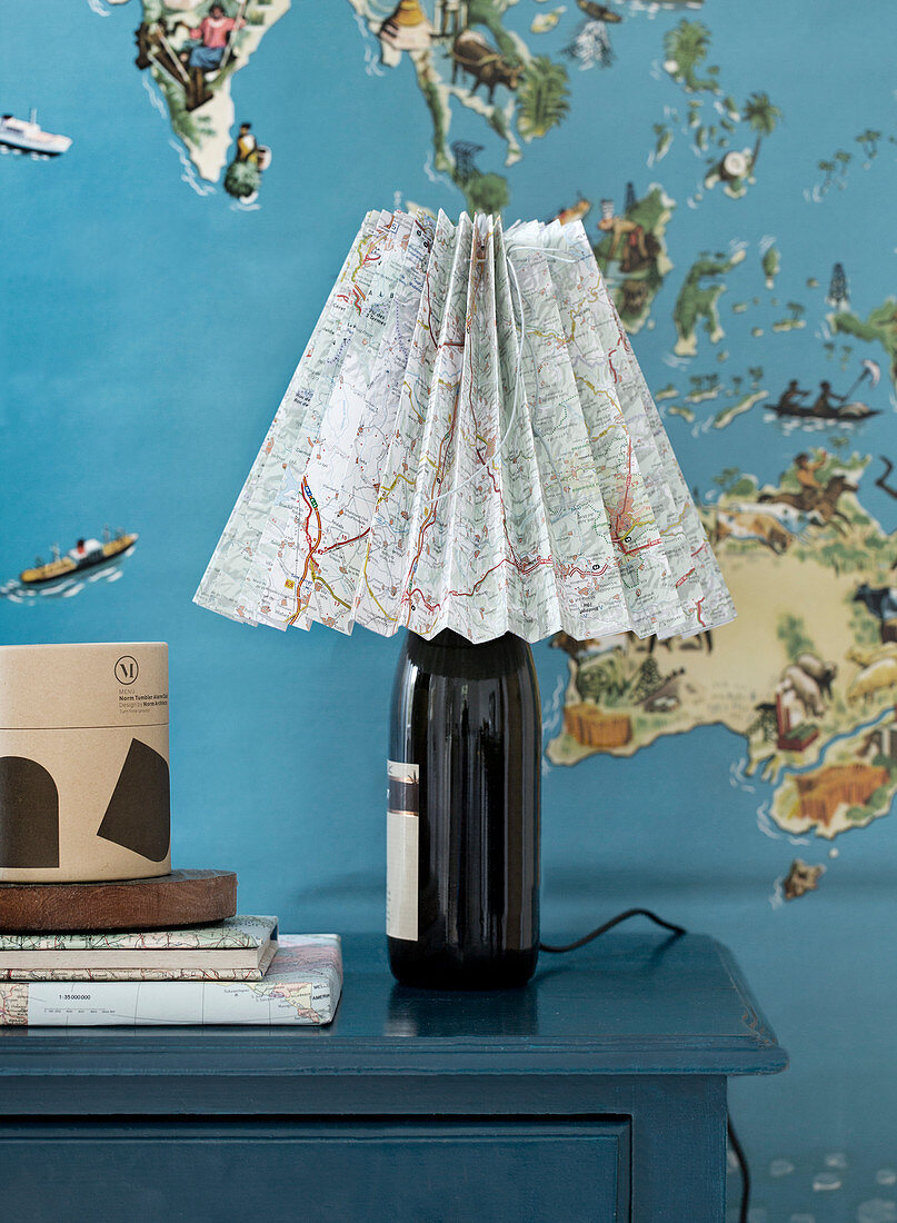 Homemade lamp from a bottle with a lampshade made from a folded map