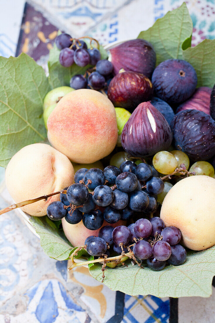 Frische Feigen, Weintrauben und Pfirsiche in einer Schale