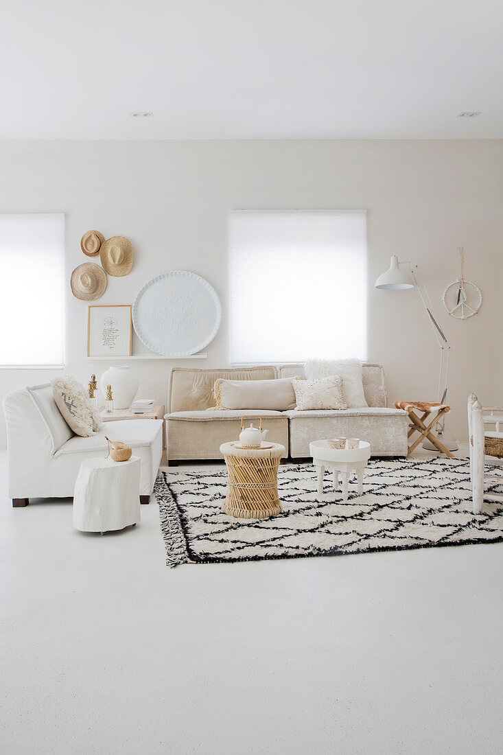 Side table on rug with diamond pattern and couches in light living room