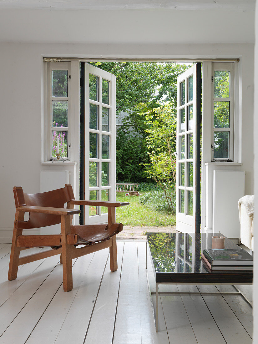 Sessel aus Holz und Leder im Wohnzimmer mit Gartenzugang