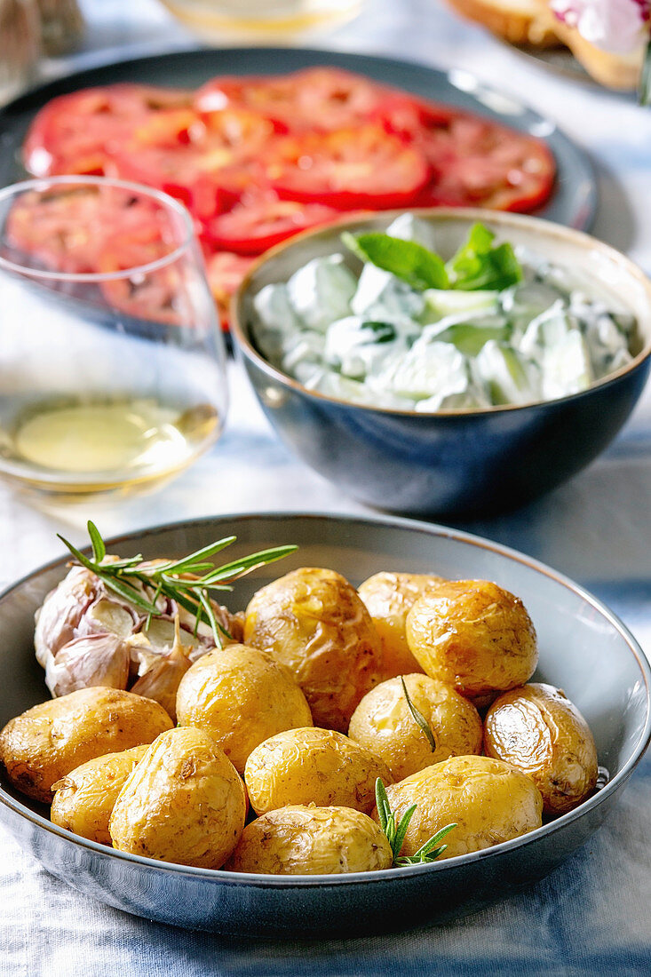 Neue ofengebackene Kartoffeln mit Gurkensalat und Tomatencarpaccio