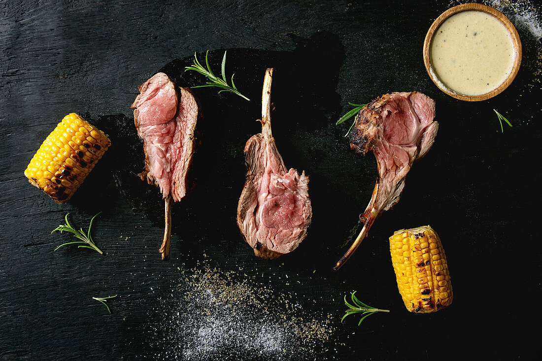 Grilled bbq rare rack of lamb with sweet corn cobs, rosemary and cheese sauce