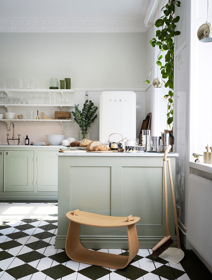 Modern stool in front of the kitchen island in a classic kitchen with a checkerboard floor